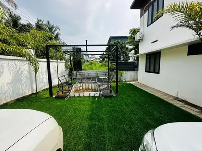a backyard with a couch on the grass at MEDURE International in Kottakkal
