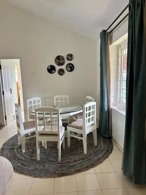 a dining room with a table and four chairs at Hoopoe House, Ooty in Ooty