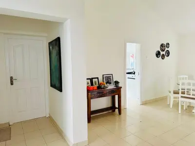 a room with a table and a white wall at Hoopoe House, Ooty in Ooty