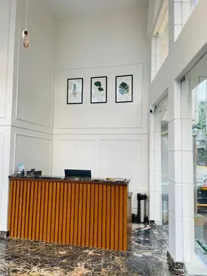 a lobby with a wooden counter in a building at Hotel Emora Tree in Mysore