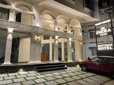 a building with a red car parked in front of it at Hotel Emora Tree in Mysore