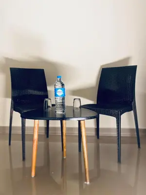 a bottle of water on a table with two chairs at LOYAL RESIDENCY in Sultan Bathery