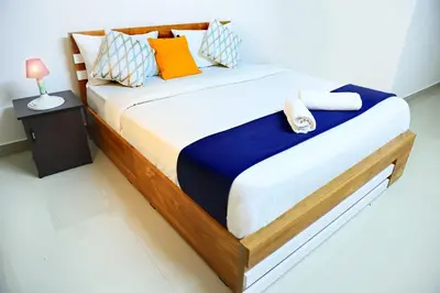 a bedroom with a large bed with colorful pillows at LOYAL RESIDENCY in Sultan Bathery