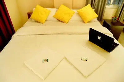 a bed with two pillows and a laptop on it at LOYAL RESIDENCY in Sultan Bathery