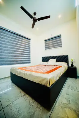 a bedroom with a bed with a ceiling fan at Shams al Imarat in Palakkad