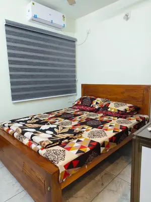 a bed with a quilt on it in a room at Shams al Imarat in Palakkad