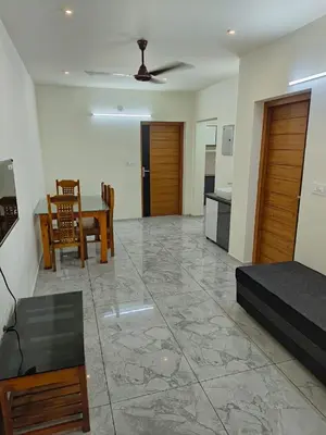 a living room with a table and a dining room at Shams al Imarat in Palakkad