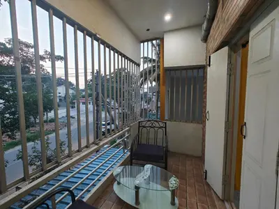 a balcony with a glass table and chairs and windows at 2Bhk holiday home in Mysore