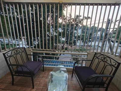 a balcony with two chairs and a table and a window at 2Bhk holiday home in Mysore