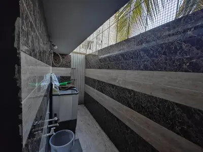 a bathroom with a concrete wall and a sink at 2Bhk holiday home in Mysore