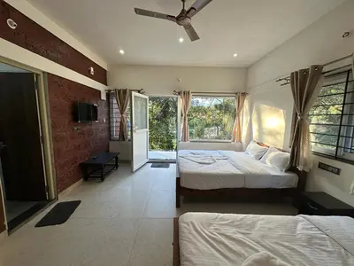a bedroom with two beds and a ceiling fan at Coorg Jungle Mist in Madikeri