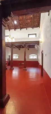 an empty room with a red floor and wooden ceilings at xplorest in Mysore