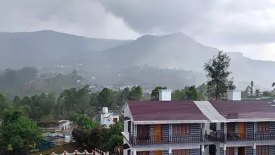 a view of a house with a mountain in the background at Moon Wings Mountain Resort in Kanthalloor