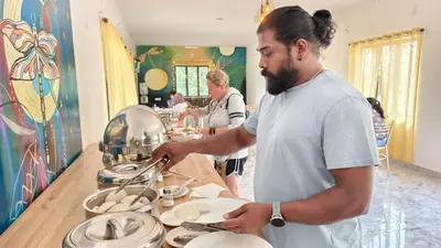 a man in a kitchen preparing food on a counter at Moon Wings Mountain Resort in Kanthalloor