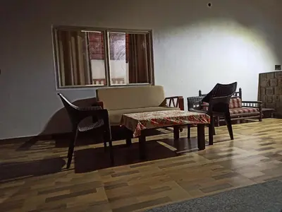 a living room with a couch and a table and chairs at Creek Side in Madikeri