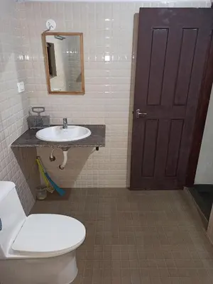 a bathroom with a toilet and a sink and a mirror at Creek Side in Madikeri