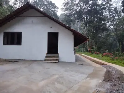 a white building with a door in the middle at Creek Side in Madikeri