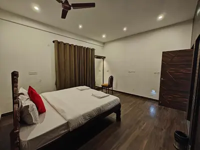 a bedroom with a bed with red pillows on it at Beautiful 4bhk Duplex Villa in Mysore