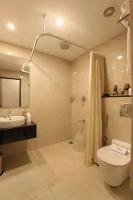 a bathroom with a toilet and a sink and a shower at HOTEL PRINCE in Kāladi