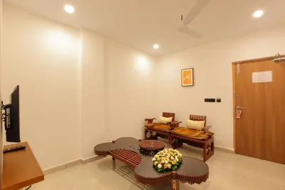 a living room with a table and chairs and a door at HOTEL PRINCE in Kāladi