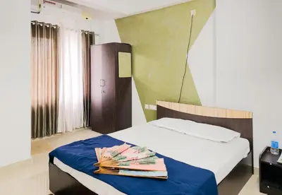 a bedroom with a bed with a blue blanket at Elite Dharshan H5 - AC 2 BHK Apartment near Guruvayur Temple in Guruvāyūr