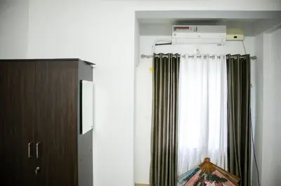 a room with a curtain and a window at Elite Dharshan H5 - AC 2 BHK Apartment near Guruvayur Temple in Guruvāyūr