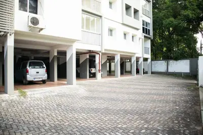 a car parked in a parking lot next to a building at Elite Dharshan H5 - AC 2 BHK Apartment near Guruvayur Temple in Guruvāyūr