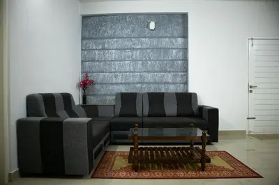 a living room with a couch and a coffee table at Elite Dharshan H5 - AC 2 BHK Apartment near Guruvayur Temple in Guruvāyūr