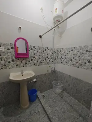 a bathroom with a sink and a pink mirror at Downtown Service Apartments in Mysore
