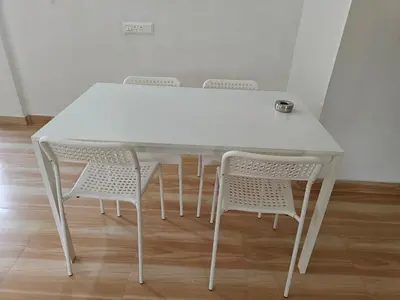 a white table with four chairs in a room at Downtown Service Apartments in Mysore