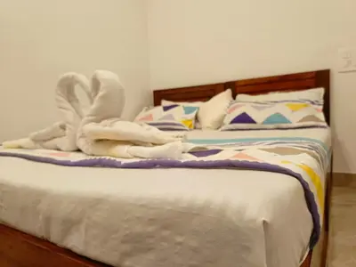 a bed with a towel animal on top of it at Paradise Homestay in Wayanad
