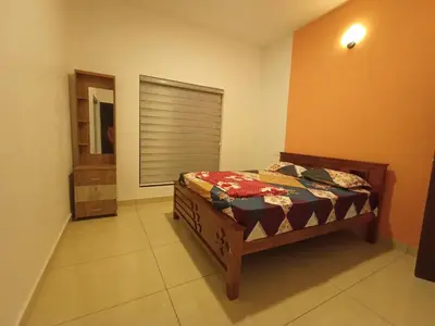 a bedroom with a bed in a room with a window at Paradise Homestay in Wayanad