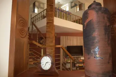a room with a clock and a spiral staircase at Golden castle in Mysore