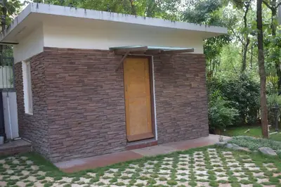 a small brick building with a brown door at Golden castle in Mysore