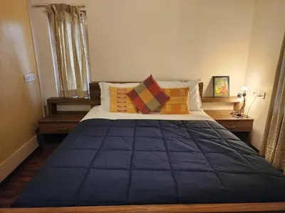 a bedroom with a large blue bed with pillows at Golden castle in Mysore