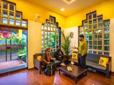 a group of men sitting in a living room at The Hosteller Wayanad, Vythiri in Vythiri