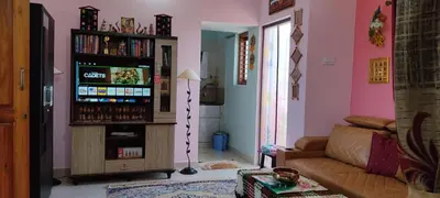 a living room with a couch and a television at Vrindavan - An Artists Nook in Mysore