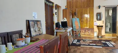 a living room filled with furniture and a painting on a table at Vrindavan - An Artists Nook in Mysore
