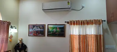 a room with three pictures and a television on the wall at Vrindavan - An Artists Nook in Mysore