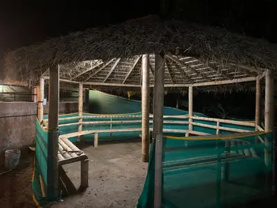 a straw hut with a bench under it at HappyDays HomeStay Wayanad in Chekadi