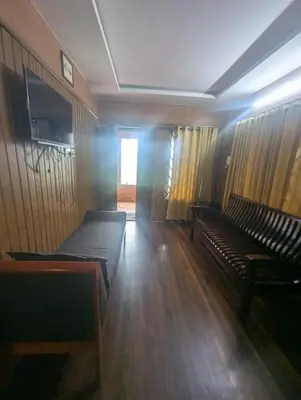 an empty room with two benches and a window at Mountain Mist Meadows in Ooty