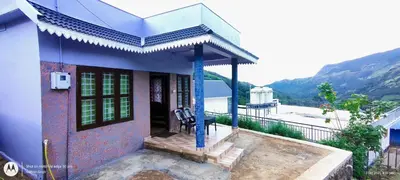a small house with a porch and a balcony at Hiya Holidays in Munnar