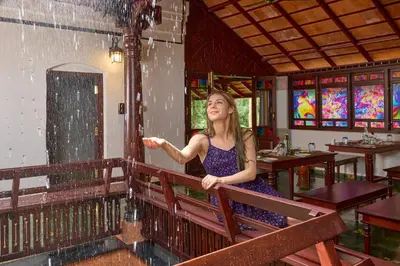 a woman standing in a restaurant in the rain at Malabar Kovilakam in Malappuram