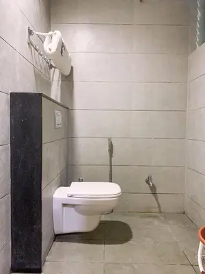 a bathroom with a white toilet in a room at New Thai Residency in Dhārāpuram
