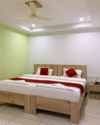 a bedroom with a large bed with red pillows at New Thai Residency in Dhārāpuram