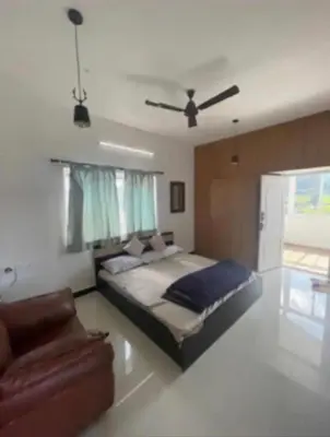 a bedroom with a large bed and a couch at White House Kotagiri, 2bhk in Kotagiri