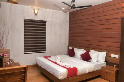 a bedroom with a bed with white sheets and red pillows at TREE6 WAYANAD in Vythiri