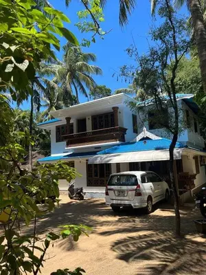 a white car parked in front of a house at Vyshnavi Home stay in Thanniyam