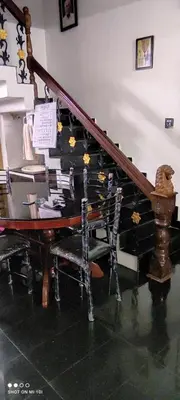 a staircase with a desk and a piano with flowers on it at Vyshnavi Home stay in Thanniyam