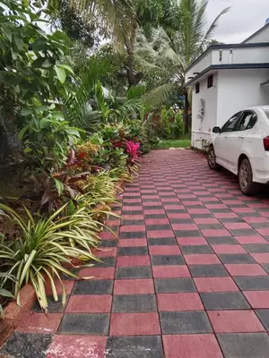 a driveway in front of a house with a car at Vythiri Garden in Vythiri